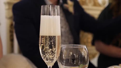 55m. A glass of sparkling champagne on the festive table.
