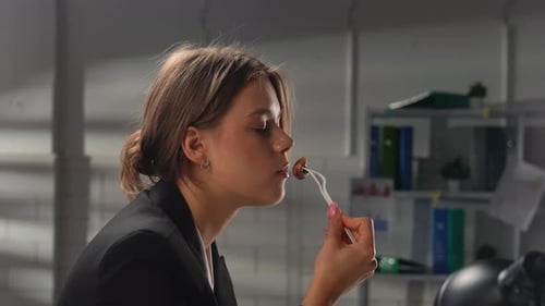 Woman in Suit Eating Lunch at Office Desk During Break