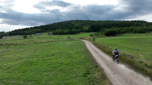Aerial Shot of a Motocross Rider on a Journey on a Dirt and Dusty Country Road Driving Fast and