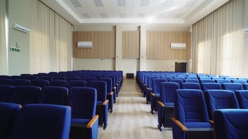 Motion Along Passway Between Empty Chairs in Conference Hall
