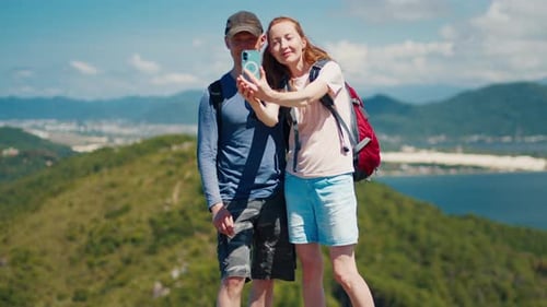 Family hiking. Couple takes selfie on a view point during their hiking trip
