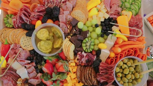 Top View of Colorful Charcuterie Board With Meats Cheeses Fruits