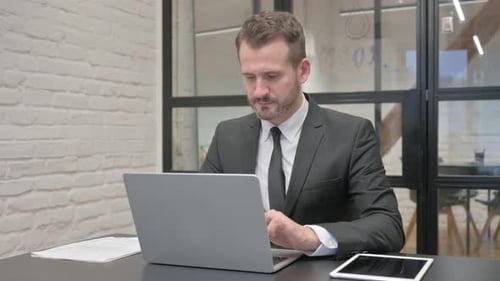 Professional Man Working on Laptop in Office