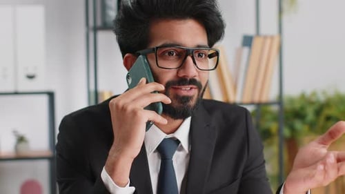 Indian Business Man Working Having Mobile Phone Talk at Office Workplace Using Messenger Chat Apps