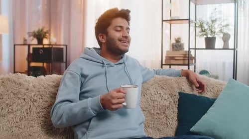 Man Relaxes with Coffee on Couch