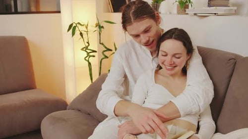 Loving Couple Reading Book Together on Couch