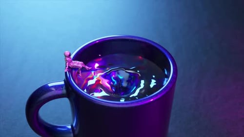 Escena surrealista en miniatura con una taza morada con un líquido colorido y un pequeño astronauta descansando