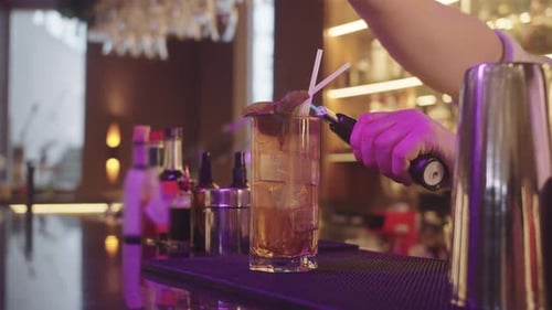 Bartender Torching Cocktail Garnish with a Flame
