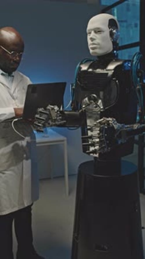 Black Engineer Activating Human Like Robot on Laptop