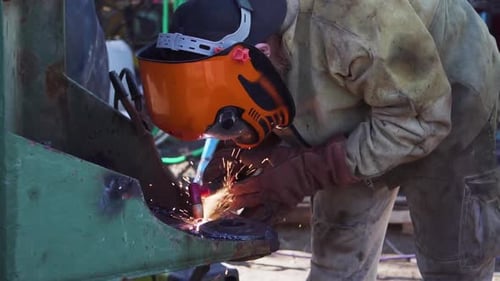 A Welder Welding A Circular Metal With A Tungsten Electrode - close up slowmo