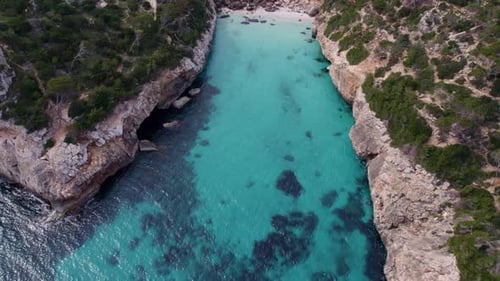 Aerial view of cove with clear water and serene shoreline, Spain.