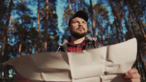 Man Navigating in Forest with Topographic Map