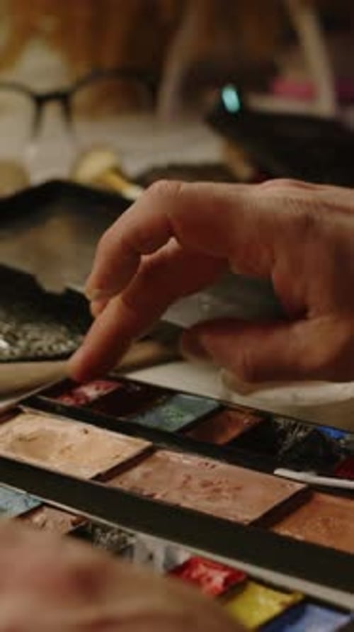 Close Up Hand Mixing Watercolors with Cotton Swab