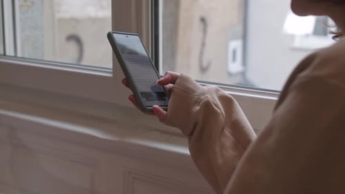 Woman using smartphone, cellphone, mobile in sweater