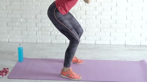 Woman Exercising, Doing Squats in Bright Room