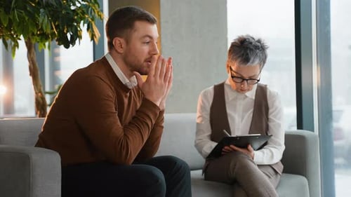 Gestresster Mann diskutiert Probleme mit Psychologin