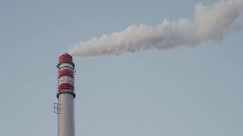 Industrieller Schornstein, der Rauch, Luftverschmutzung in den Himmel ausstrahlt, Fernwärmekessel, Bioenergie