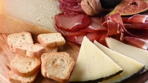 Planche de charcuterie avec fromage, raisins et figues