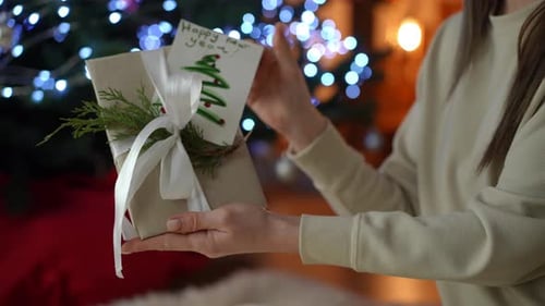 Woman Holds Christmas Gift in Cozy Home Setting