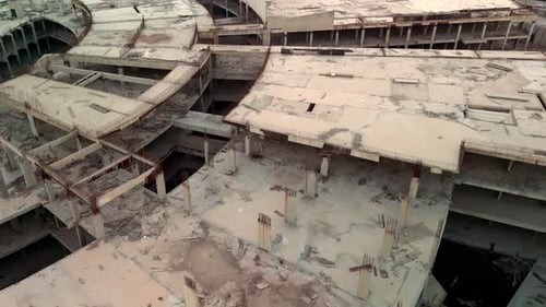 Zumbido aéreo de un sitio de construcción de un edificio de concreto abandonado con columnas de barras de refuerzo expuestas