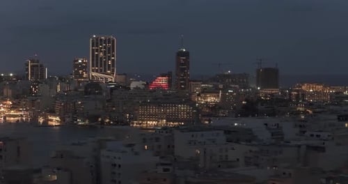 Aerial view of city buildings at night, Malta.