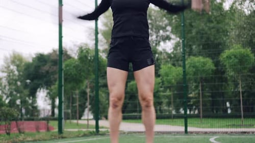 Woman Jumps Rope on Sports Field for Fitness