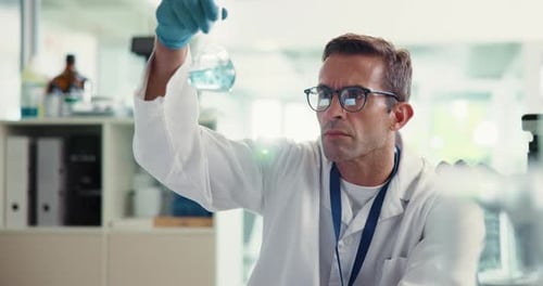 Scientist Examines Flask of Blue Solution in Lab