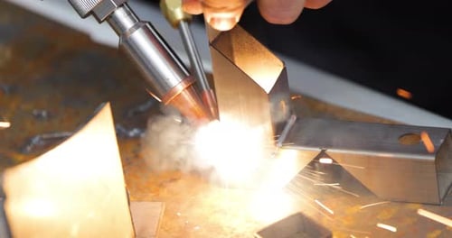 Laser welding machine with hand hold gun. Laser welding is shown in close-up.