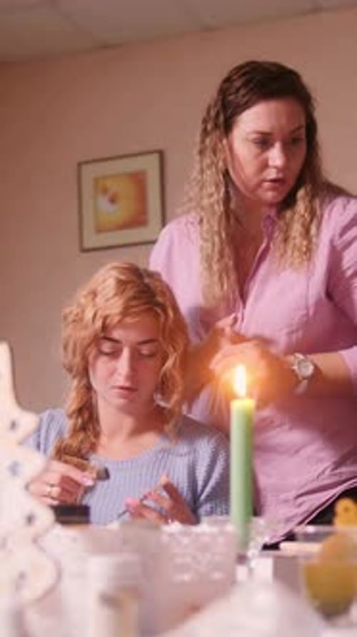 Teen and Woman Crafting at Home with Candlelight