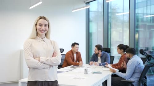 Portrait of a smiling business woman on background diverse team employees at workplace in a office.