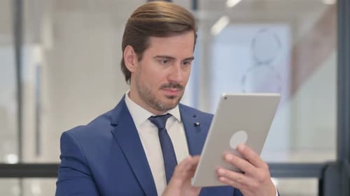 Man in Suit Using Tablet in Office