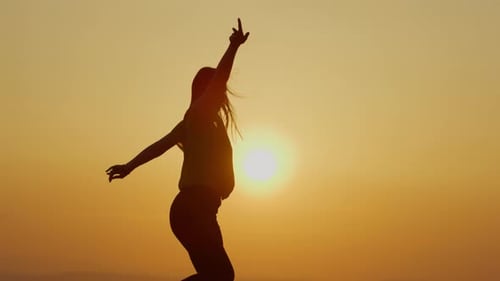 Woman Silhouette Dancing in Golden Sunset