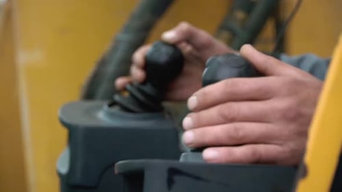 An Operator Skillfully Controls Heavy Machinery Utilizing a Precision Joystick for Efficiency