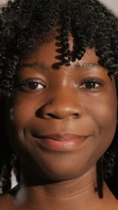 Modèle féminin détendu avec un sourire éclatant, expression joyeuse authentique capturée dans un cadre de studio animé