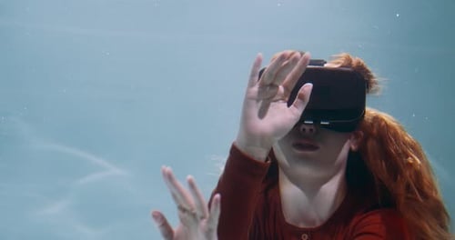 Amazing Cinematic Under Water Shot of Young Beautiful Happy Woman in VR Headset Touching Invisible