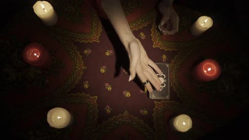 Ansicht von oben Die Wahrsagerin legt ein Deck mit Tarotkarten auf den Tisch. Kundin wählt drei Karten aus