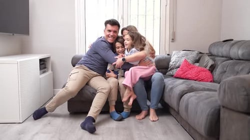 Happy Family Embracing on Couch Indoors