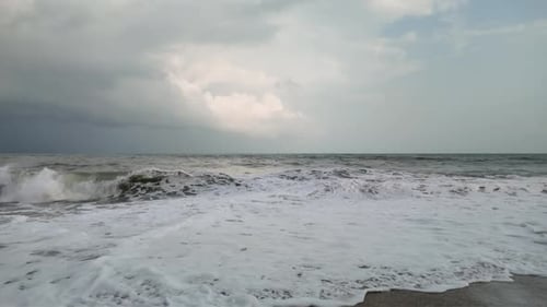 Slow Motion of Waves Crashing onto Sandy Beach, Overcast Summer Day