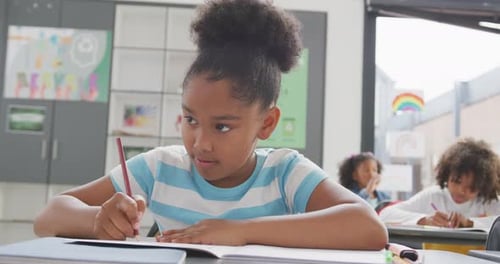 Happy Girl Writing in Classroom