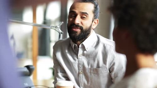 Man Smiling and Talking During Work Meeting