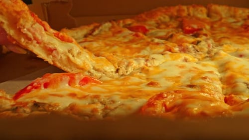 Hand Takes Slice of Cheesy Pizza From Box