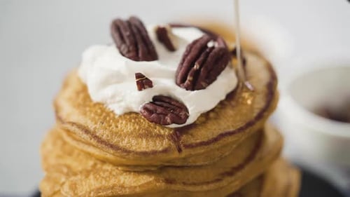 Pancakes Topped with Syrup, Cream, and Pecans
