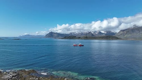 Wellboat sails through Gimsoystraumen in Lofoten with mountains in spring sunlight