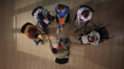 Sur la photo ci-dessus, un groupe de personnes et leur mentor sont assis sur une chaise qu'ils sont venus chercher