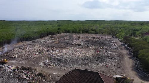 Rubbish tip, landfill, waste area in Lembongan Bali drone pull back shot low