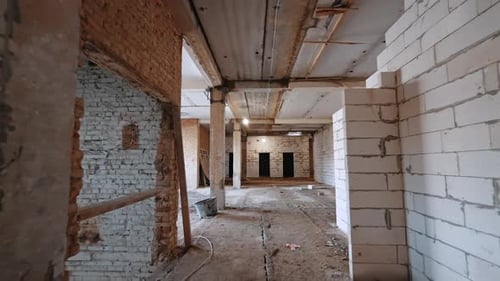 Moving by the corridor with the walls of new and old bricks.