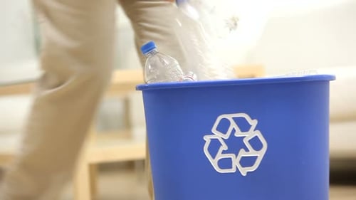Recycling Plastic Bottles into a Blue Recycle Bin