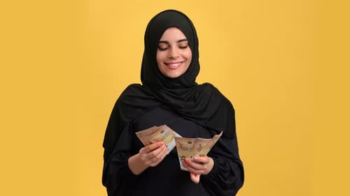 Portrait Smiling Muslim Woman in Black Hijab Counting Cash Money Euro Posing Isolated Orange Studio