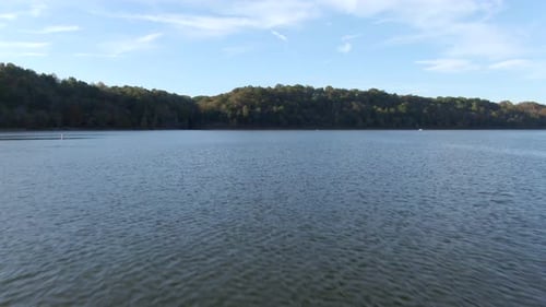 Dolly Forward Over Lake Towards a Forested Shore