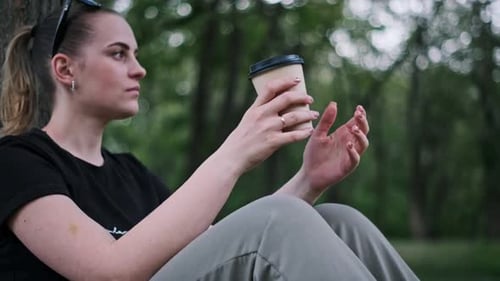 Woman Enjoying Coffee in Park